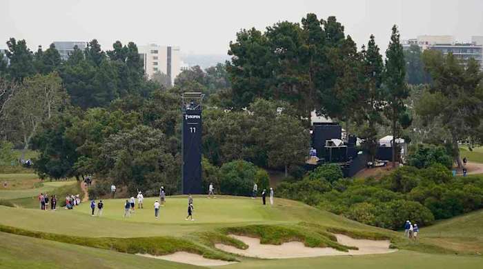 Players and caddies study the 11th green during a practice day at the 2023 U.S. Open.